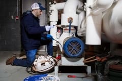 Contractor installing external self-regulating heat trace system on pipe indoors