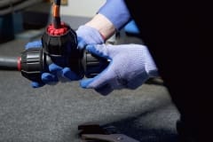 Gloved Hand Tightening Philmac Fitting onto Pipe with Retro-Line